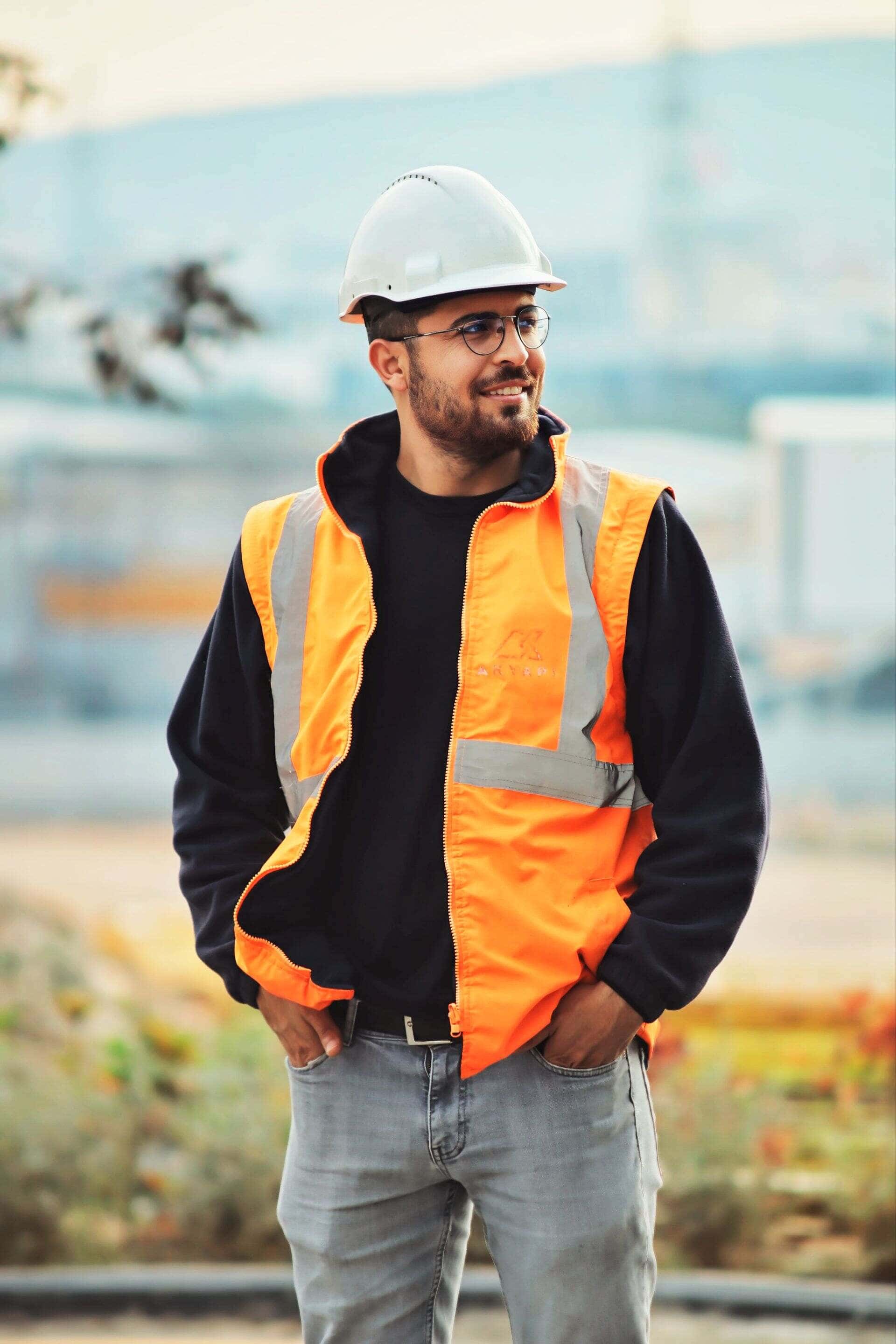 Artisan du bâtiment casqué, souriant, sur un chantier