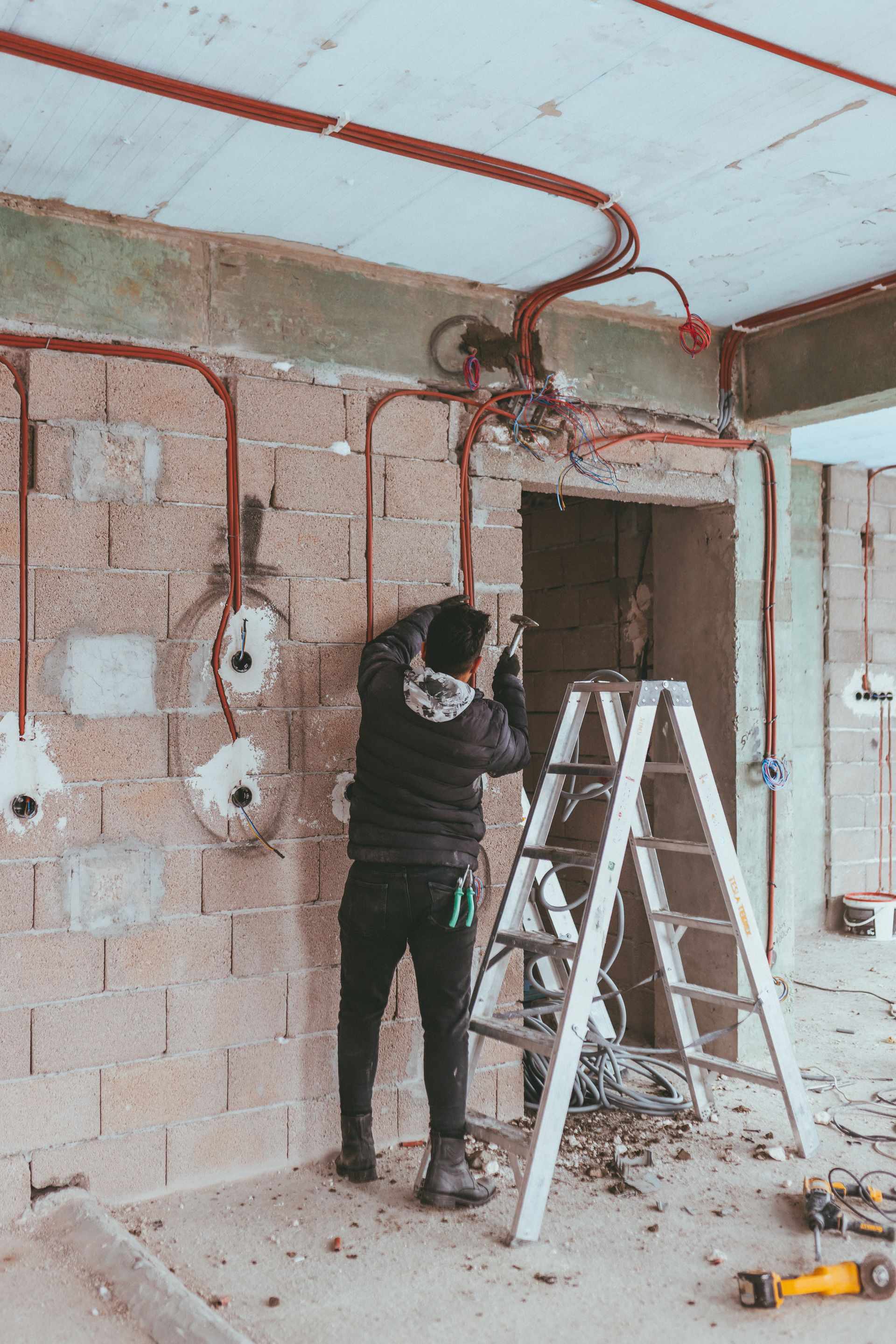 Électricien tirant les câbles dans une maison en construction