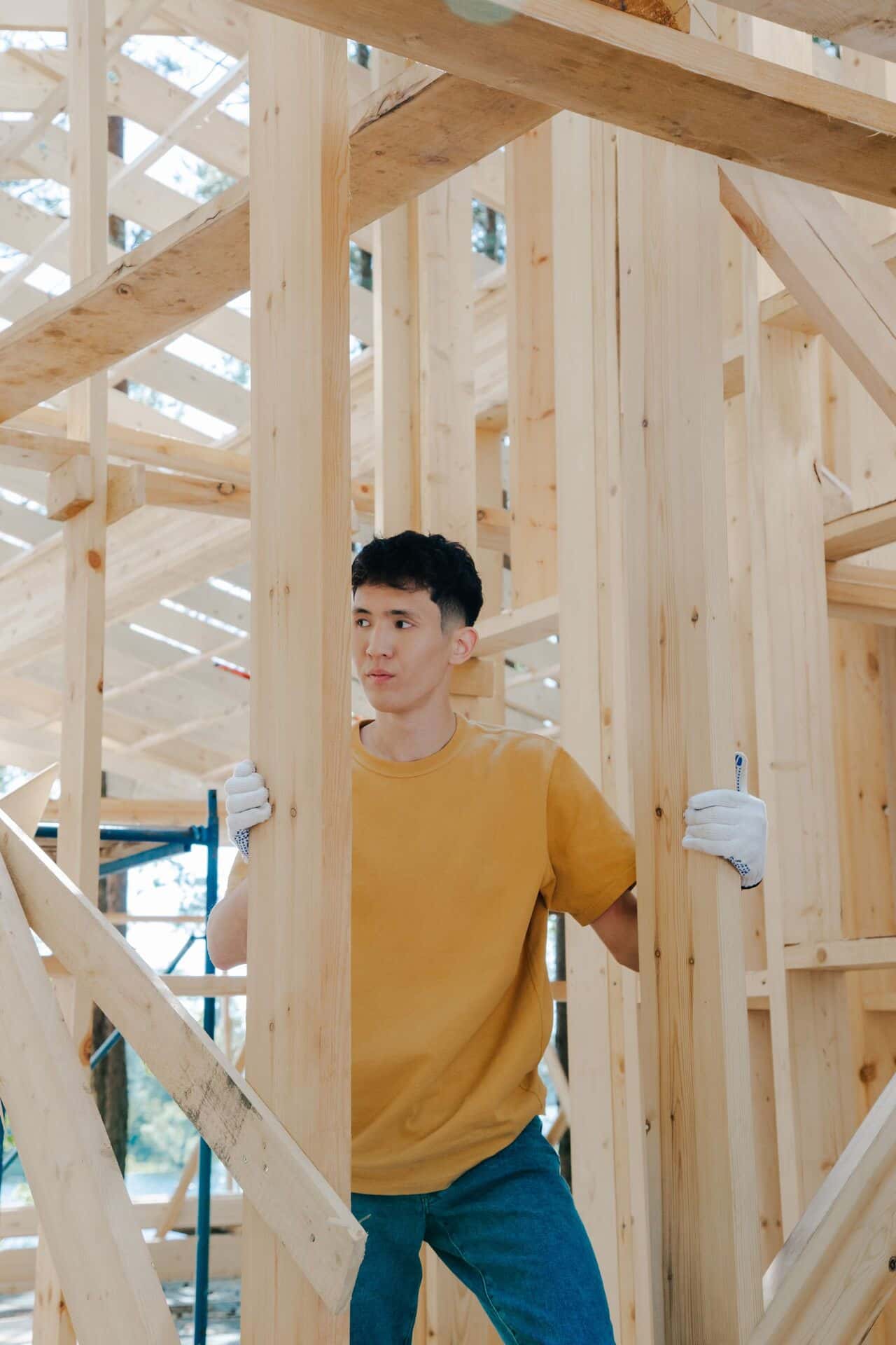 Charpentier dans l'ossature bois d'une maison en construction