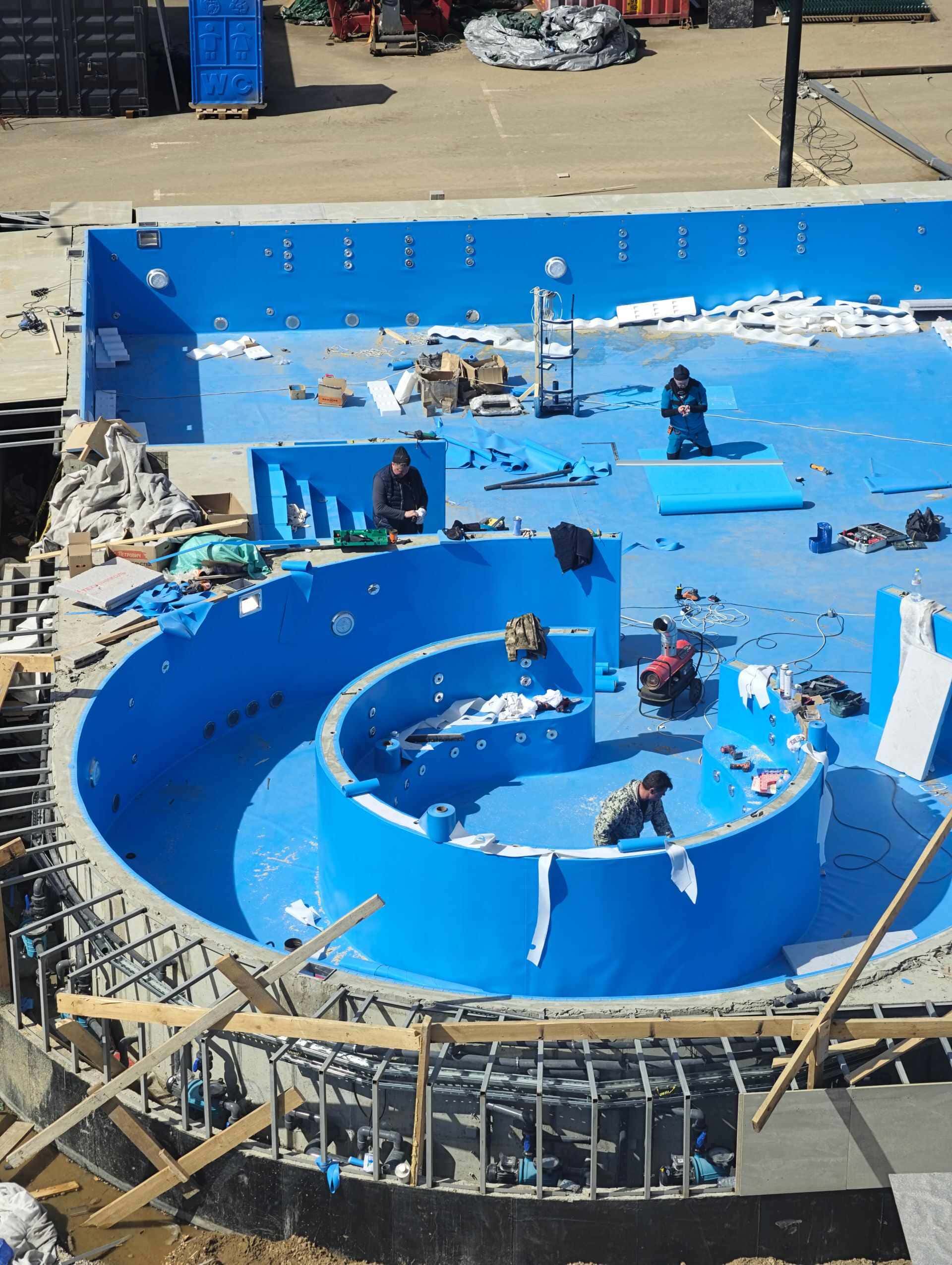 Bassin en construction, ouvriers au fond de la piscine