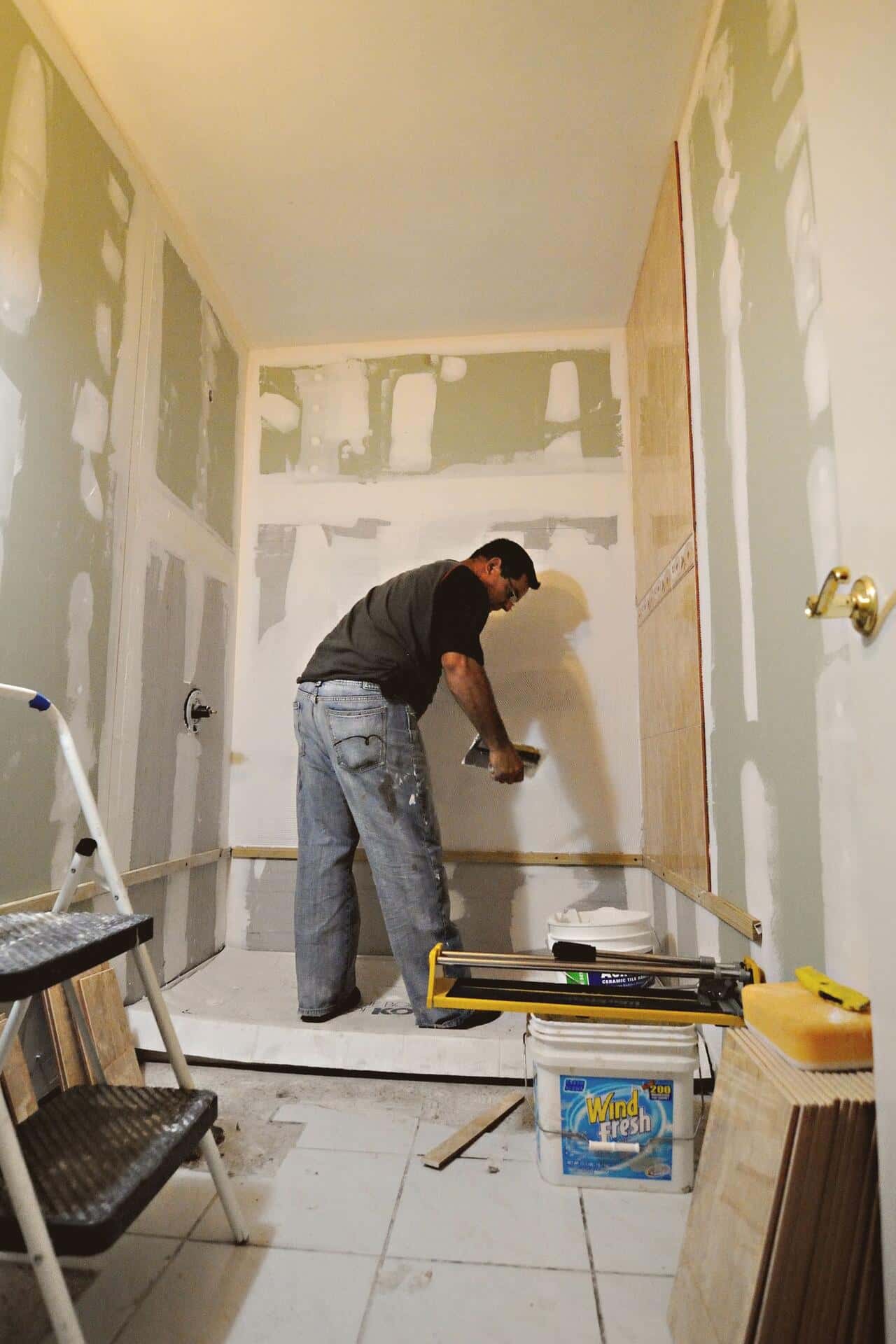 Artisan préparant les murs d'une douche pendant la rénovation d'une salle de bain