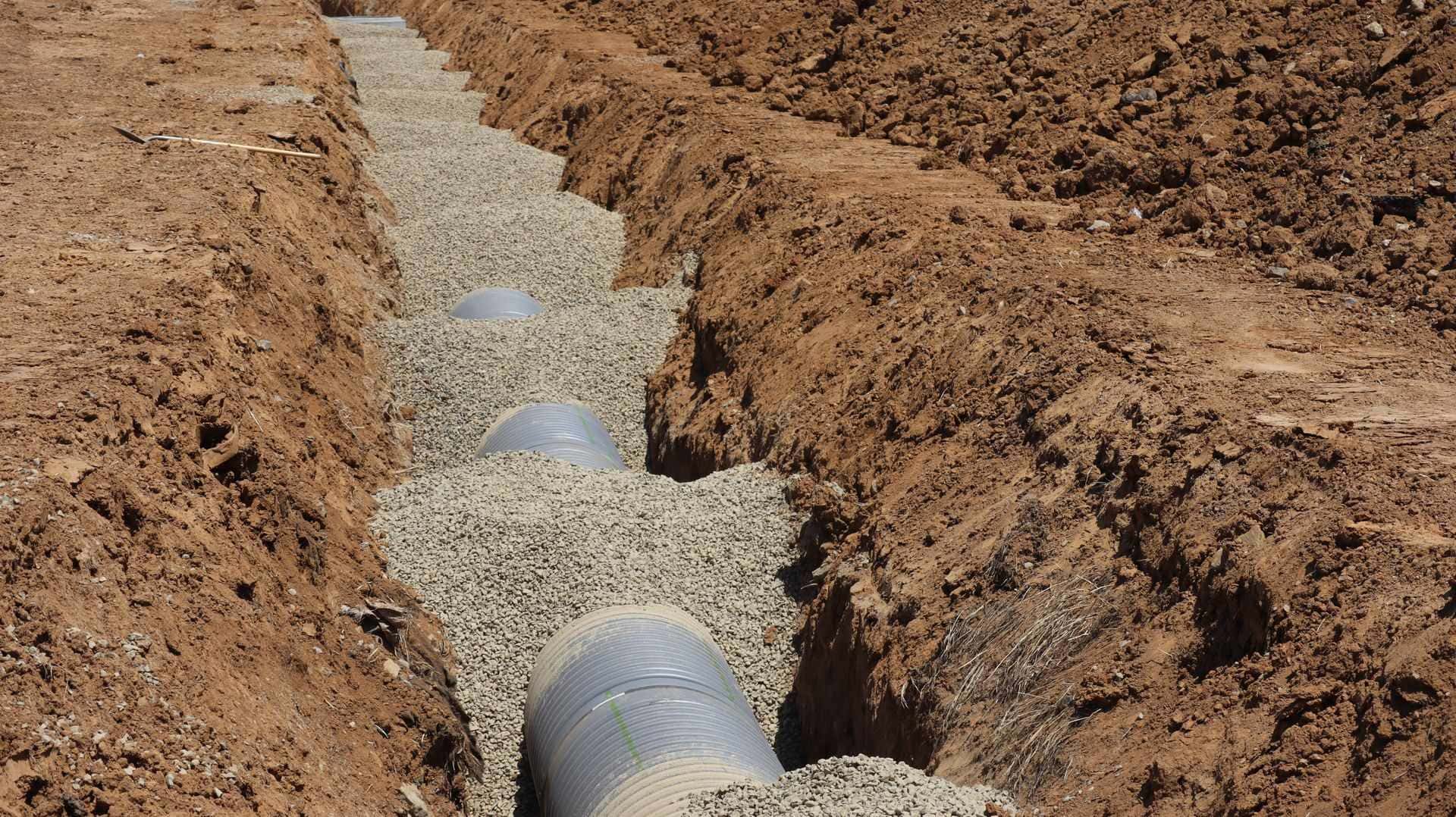Canalisation posée dans une tranchée sur gravier, chantier de réseaux